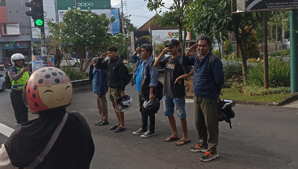 Bripka Arief Purwoko menghukum para pelanggar jalur sepeda dengan sikap hormat di pinggir jalan sekitar Bayeman, Rabu (7/1/2026).