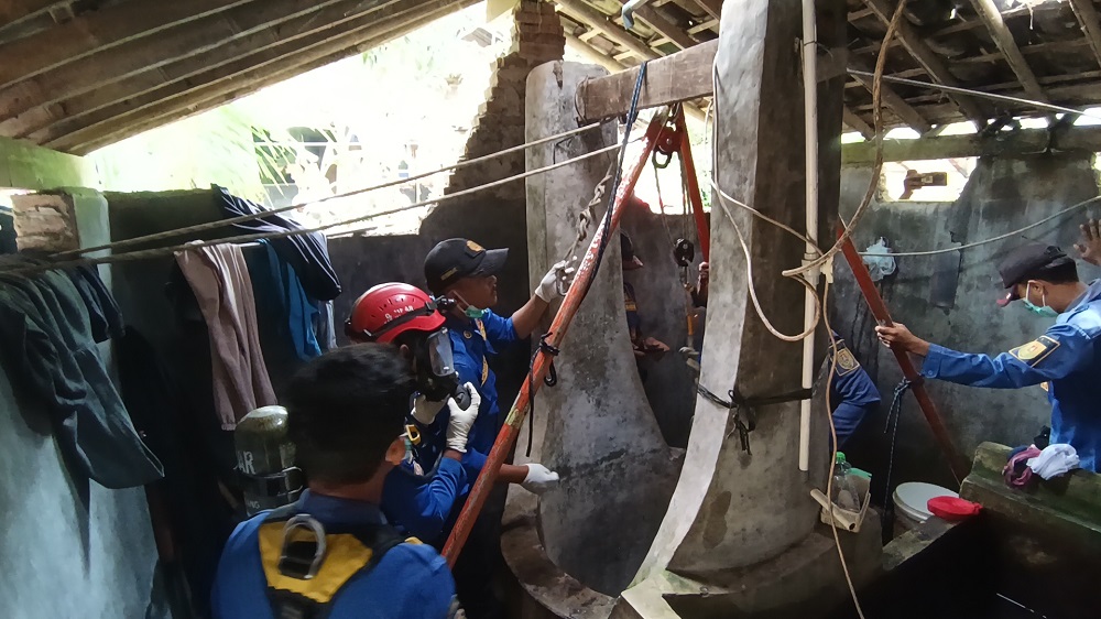 Anggota Damkar Kabupaten Magelang saat mengevakuasi korban dari dalam sumur.