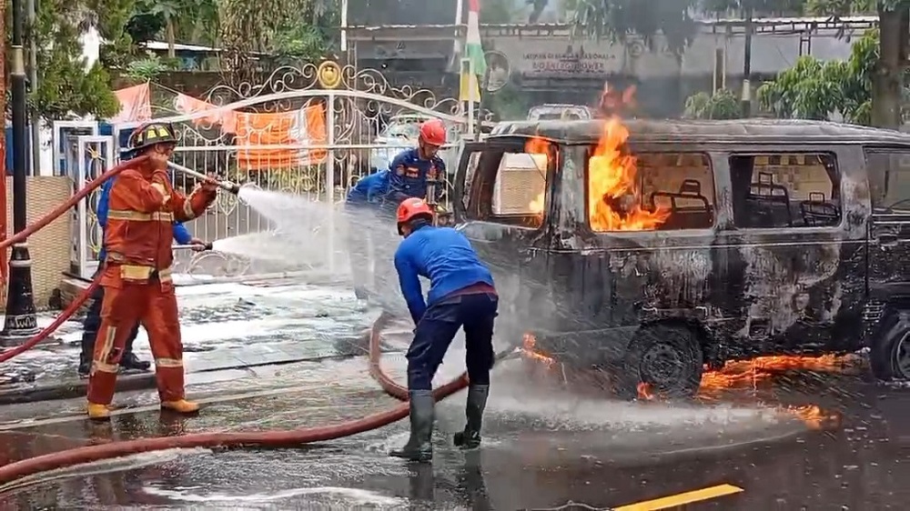 Petugas Damkar Kabupaten Magelang saat memadamkan api yang membakar mobil Suzuki Carry di Jalan Jenderal Sudirman, Wringinputih, Borobudur, Kabupaten Magelang, Rabu (14/1/2026).&nbsp;