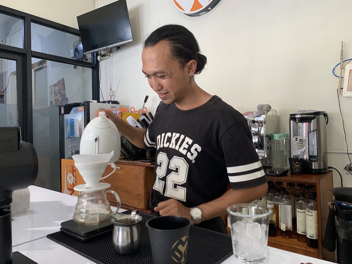 Barista Kedai Kopi Mak Ridjah sedang menyiapkan minuman pesanan pembeli.