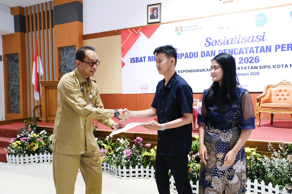 Asisten Pemerintahan dan Kesejahteraan Rakyat Sekda Kota Magelang Catur Budi Fajar Sumarmo menyerahkan akta pencatatan perkawinan di Gedung Wanita, Selasa (3/2/2026).