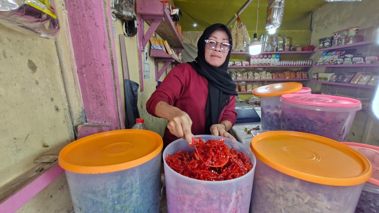 Aliyah, menunjukkan oleh-oleh khas Guci, yakni manisan papaya.