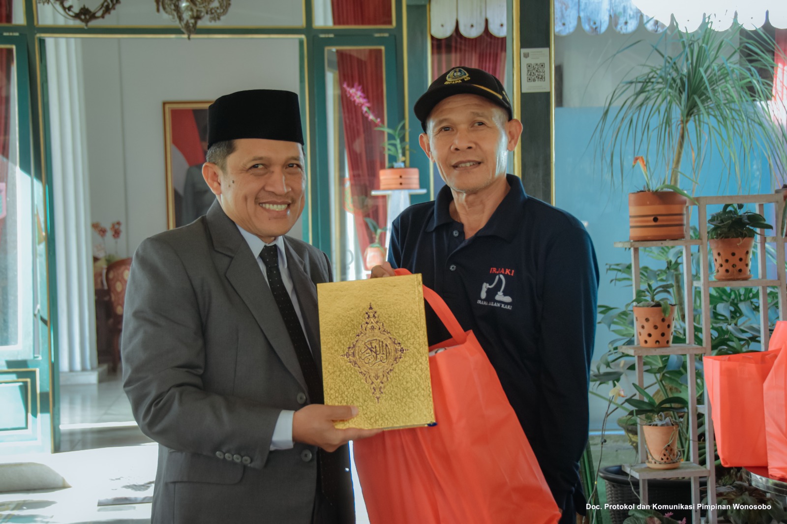 Bupati Wonosobo Afif Nurhidayat (kiri) ketik membagikan musaf Alquran.