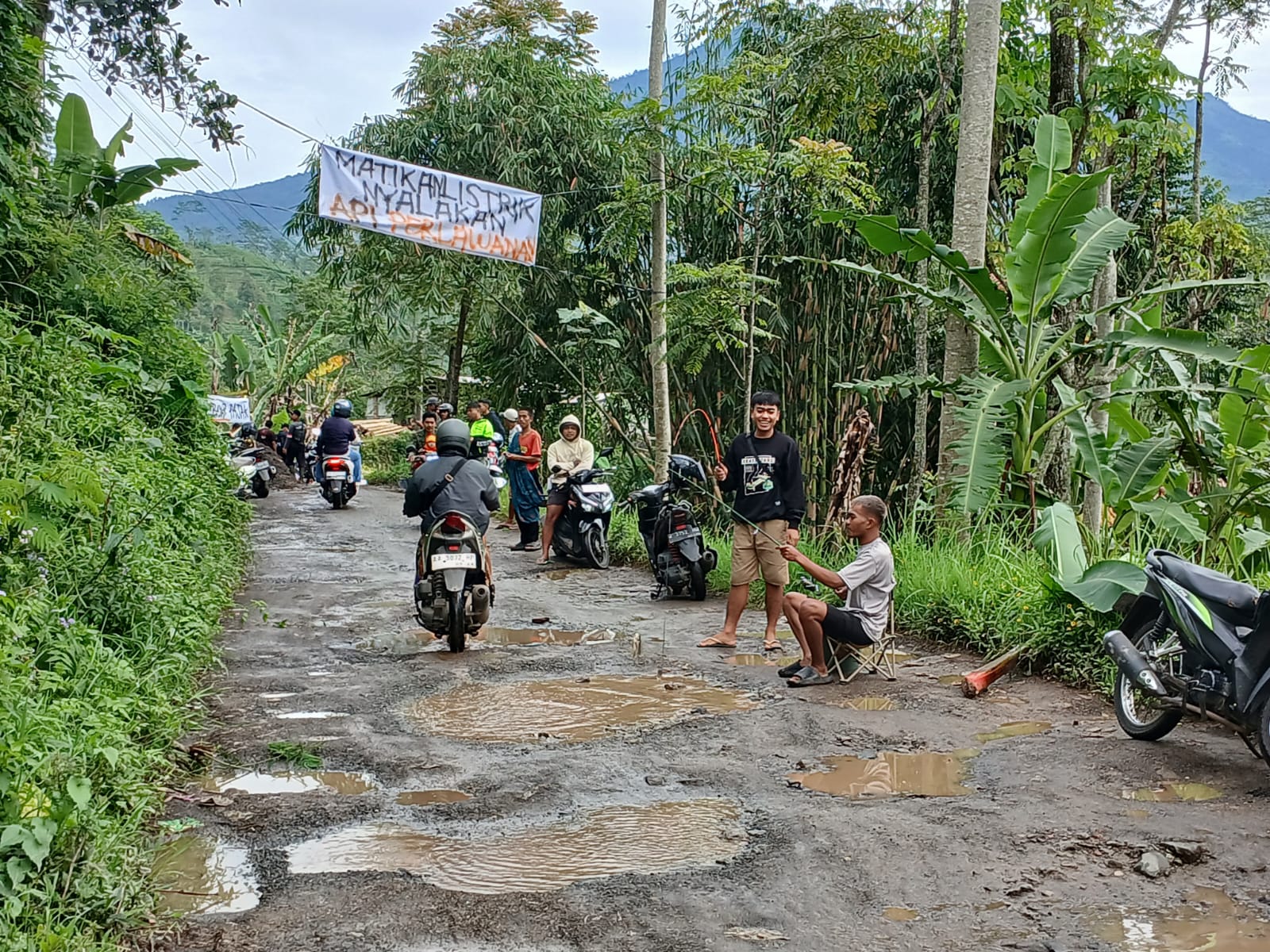 Sejumlah warga melakukan aksi memancing, mandi dan tanam pohon di kubangan ruas jalan Kalibeber-Deroduwur, kemarinj (28/22026).&nbsp; 