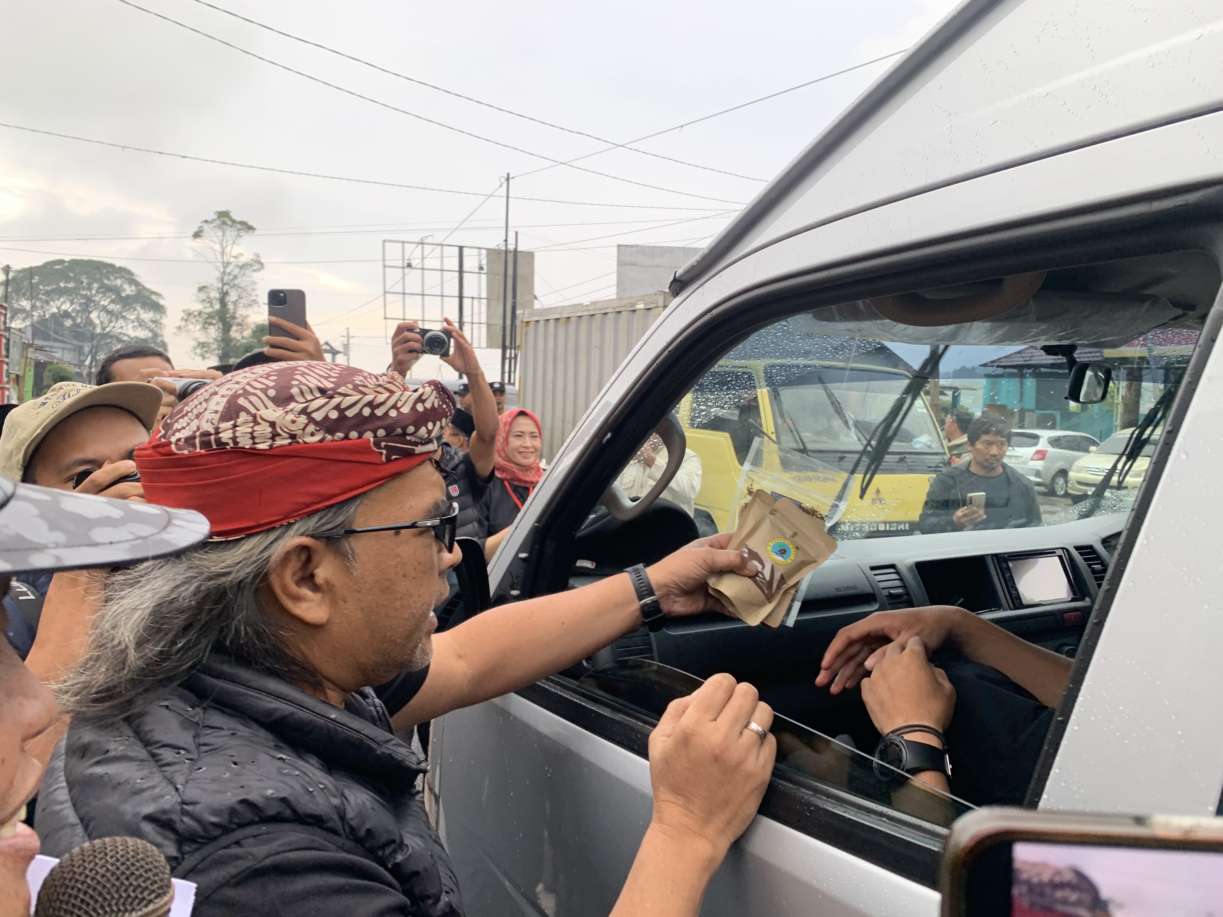 Bupati Temanggung Agus Setyawan membagikan kopi kepada pengguna jalan di jalan raya Temanggung-Wonosobo, Senin (16/3) petang dalam kegiatan sedekah kopi. 