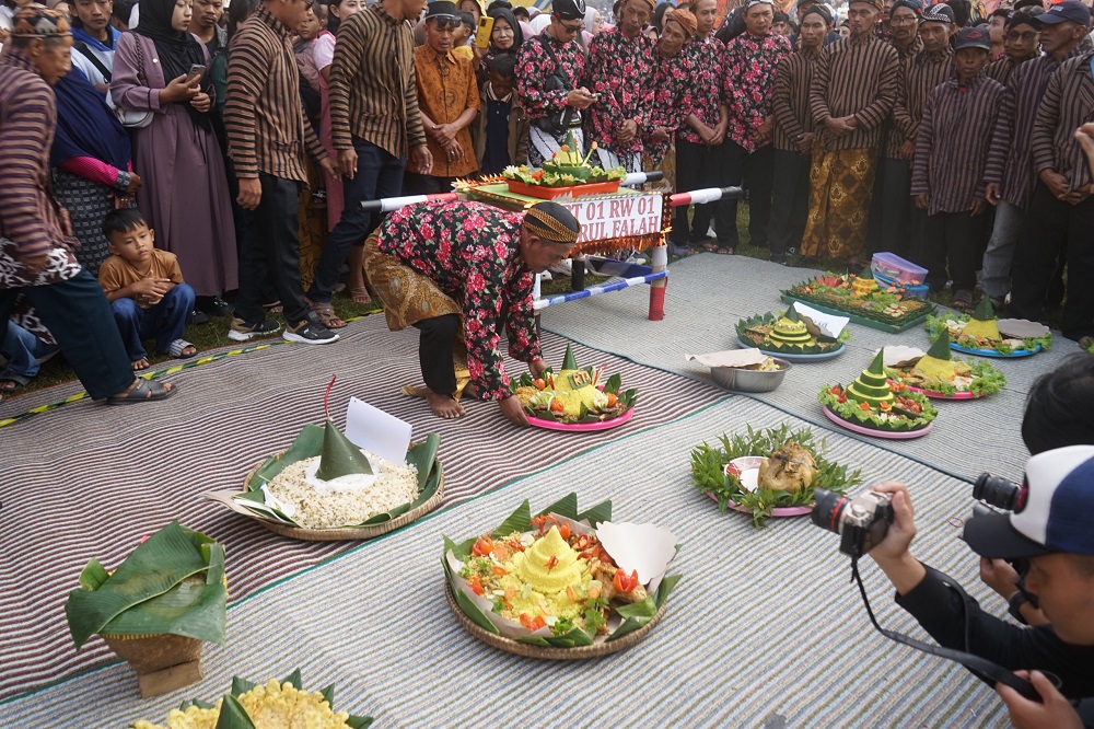 Panitia menggelar tasyakuran dengan membuat 25 tumpeng yang melambangkan kebersamaan dan upaya melestarikan adat istiadat.
