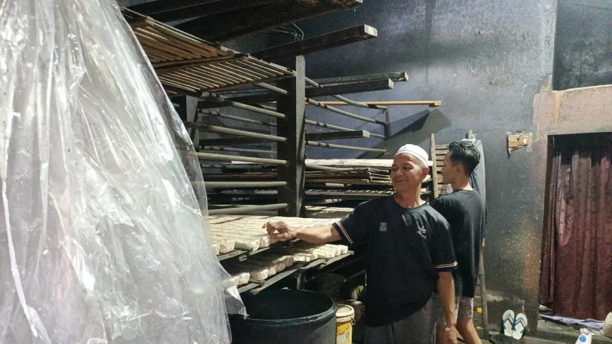 Perajin tempe H. Tamsuri menata tempe-tempe yang sudah dikemas di tempatnya Menowo, Kedungsari, Kecamatan Magelang Utara. (ROFIK SYARIF/ JAWAPOS RADAR MAGELANG)