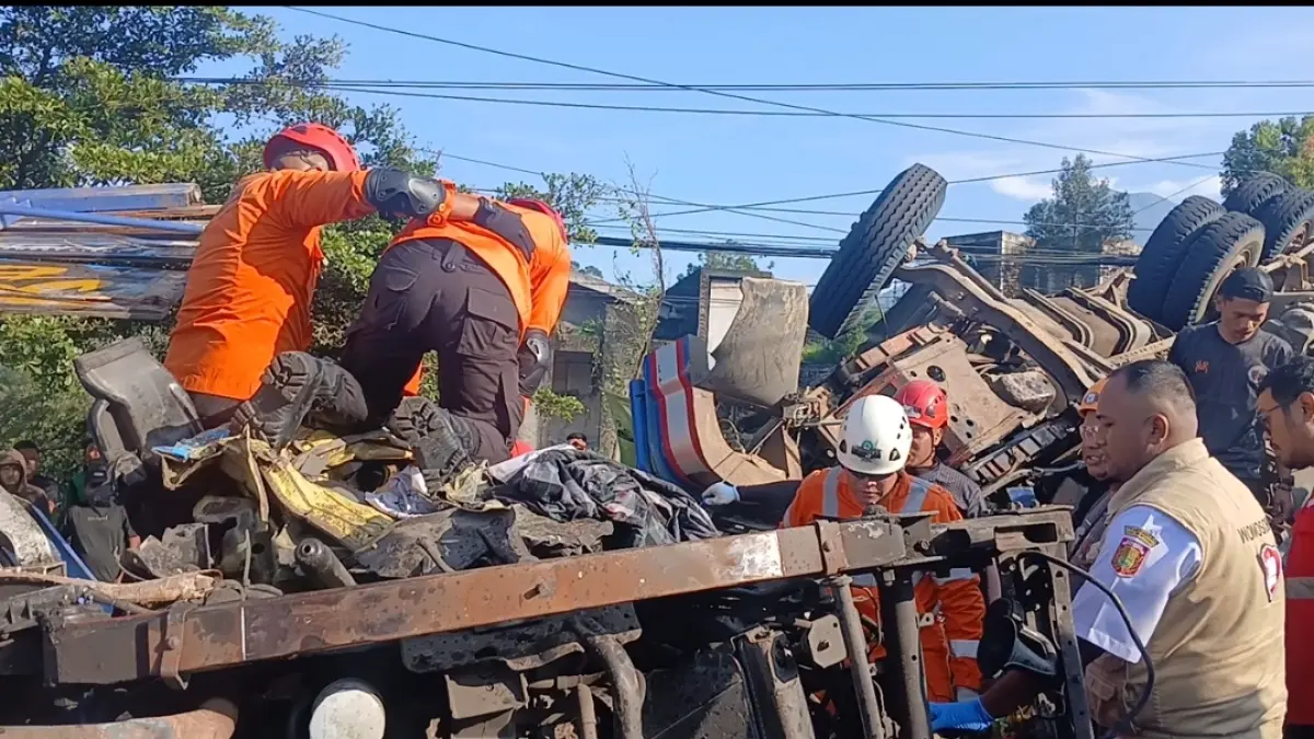 Sejumlah relawan dari BPBD, kepolisian dan warga mencoba mengangkat bangkai truk dan mengatur arus lalulintas di TKP, Rabu (8/4/2026). 