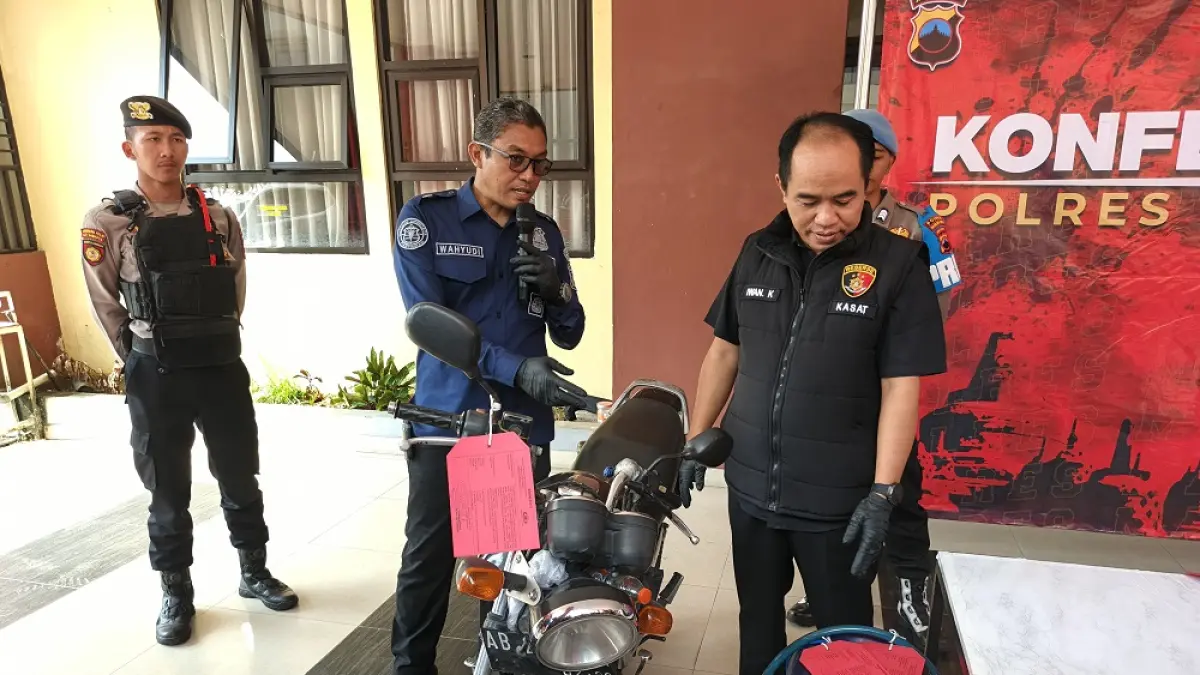 Kasat Reskrim Polres Magelang Kota AKP Iwan Kristiana bersama Kasi Humas Ipda Wahyudi menunjukkan barang bukti sepeda motor dan jerigen berisi pertalite, Jumat (17/4/2026). (ROFIK SYARIF/ JAWA POS RADAR MAGELANG)