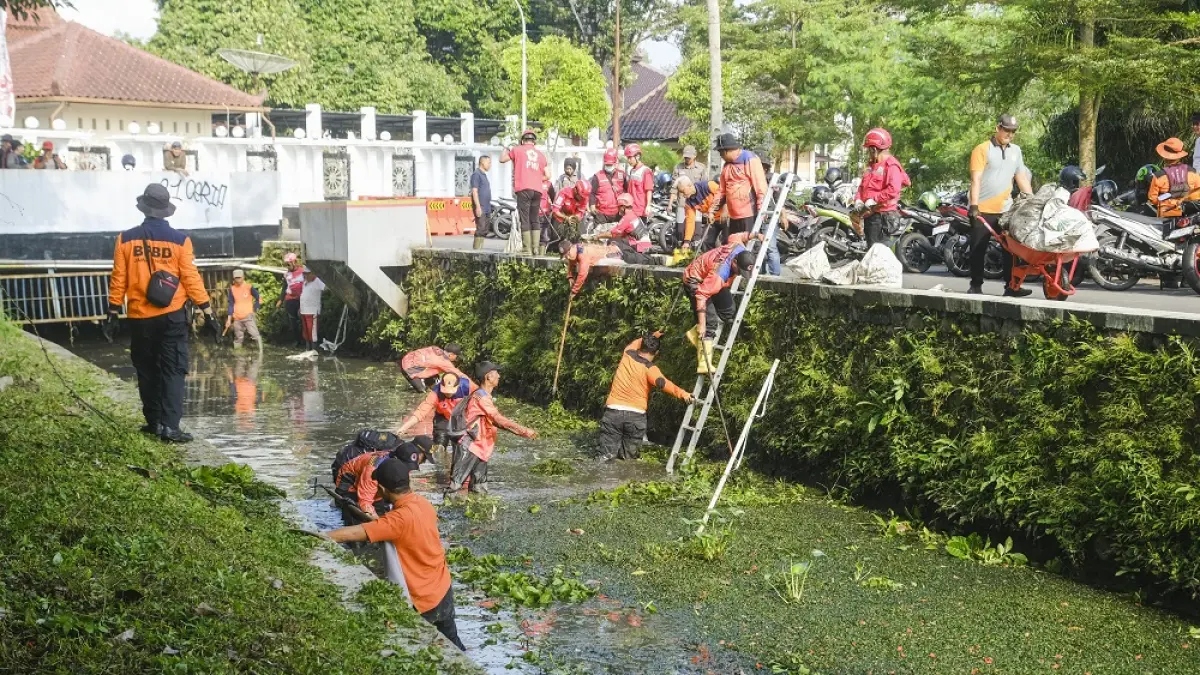 Relawan gabungan melakukan pembersihan sungai yang melintasi kompleks rumah dinas wali kota Magelang.&nbsp;