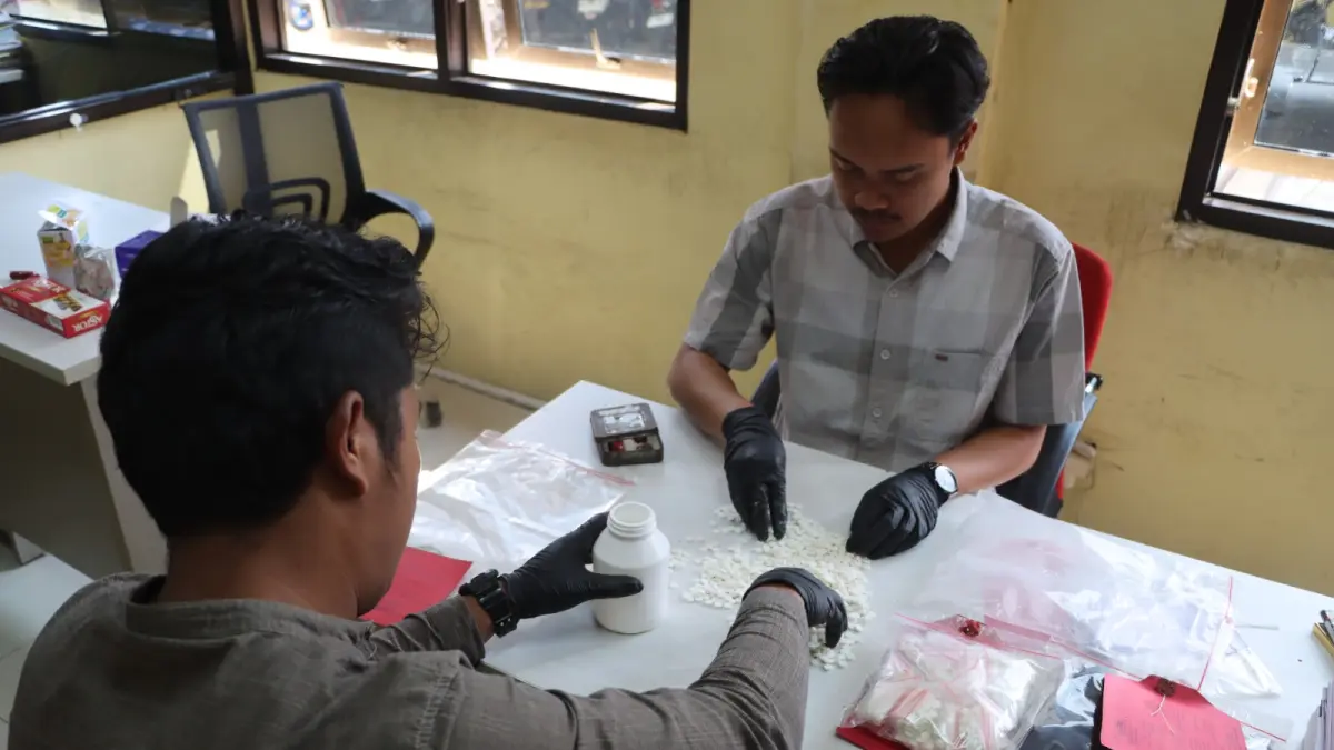 Petugas Satresnarkoba Polres Wonosobo memeriksa pil yang disita dari tersangka AAS, warga Wonosobo. (Dok Humas Polres Wonosobo)
