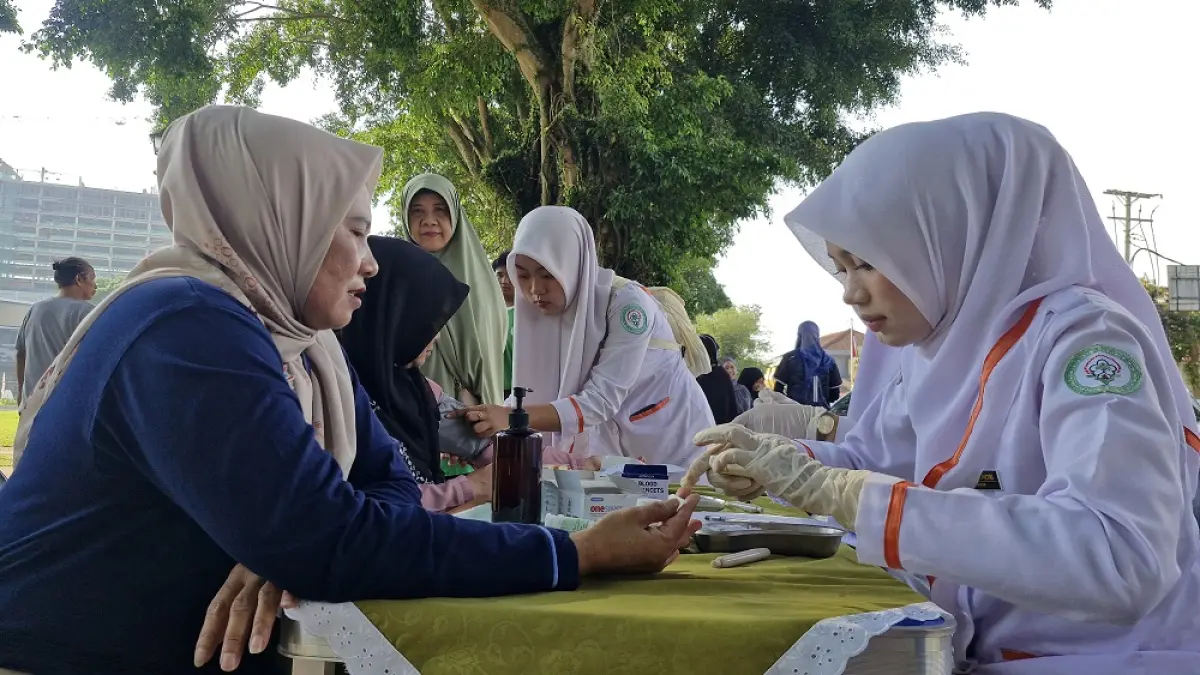 Siswa SMK Citra Medika Kota Magelang melayani masyarakat yang menginginkan cek kesehatan gratis di Alun-alun Kota Magelang, Jumat (8/5/2026). (PUPUT PUSPITASARI/JAWA POS RADAR MAGELANG)