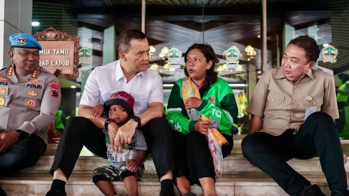 Gubernur Jateng Ahmad Luthfi berbincang dengan Ratna Yuniarti, driver ojol asal Kota Semarang yang bekerja di jalan sambil membawa anak balitanya, Rabu (20/5/2026) di tangga depan kantor gubernuran. (Istimewa)