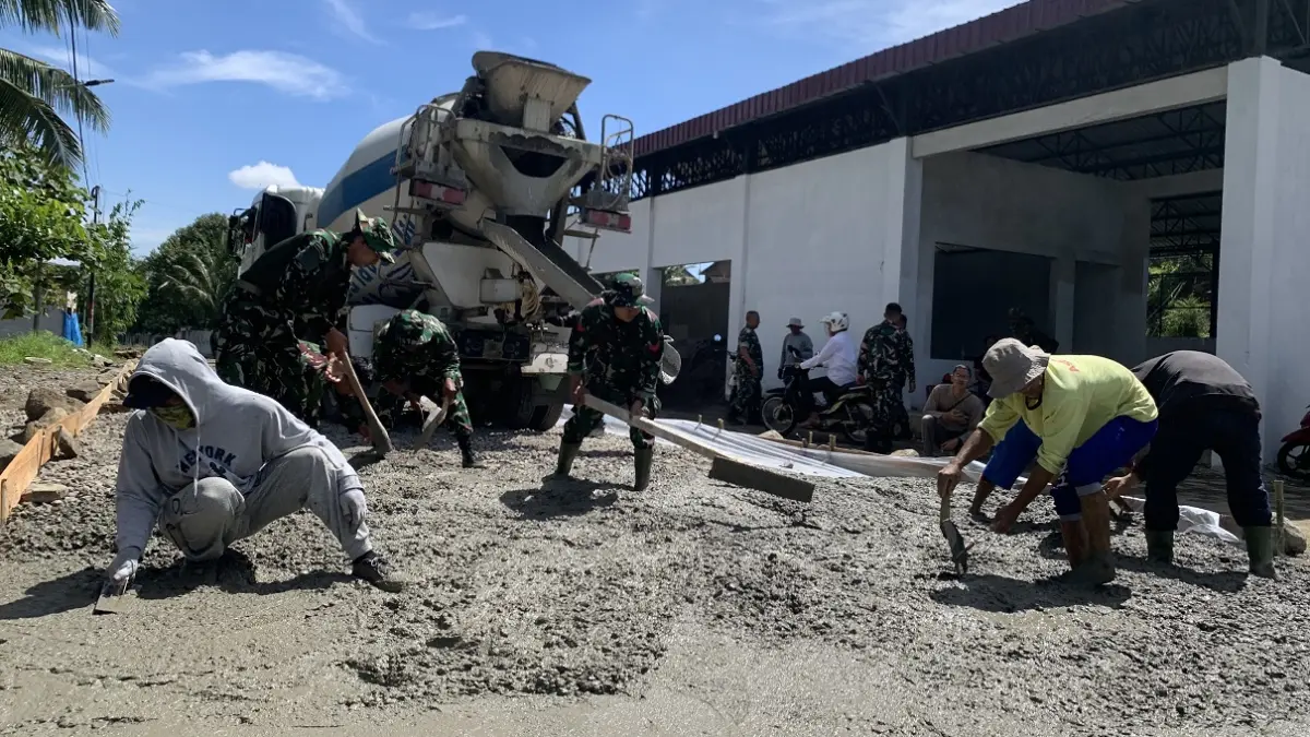 Tentara dan warga gotong royong mengecor jalan baru di depan KDMP Kaloran, Selasa (26/5/2026). (Devi Khofifatur Rizqi/Jawa Pos Radar Magelang)