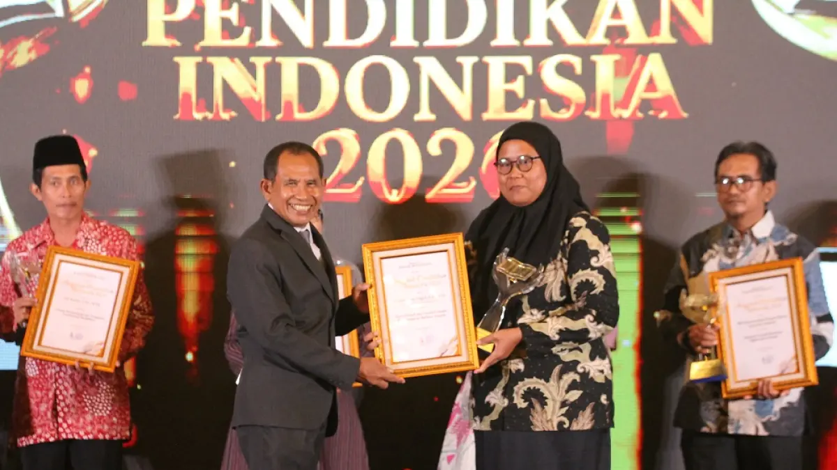 Guru SMP Negeri 2 Cepiring, Kabupaten Kendal Ana Rahmawati Ningsih, S.Pd., M.Pd. saat menerima piala dan piagam dari Direktur Jawa Pos Radar Semarang H. Baehaqi. (BASKORO SEPTIADI/JAWA POS RADAR SEMARANG)
