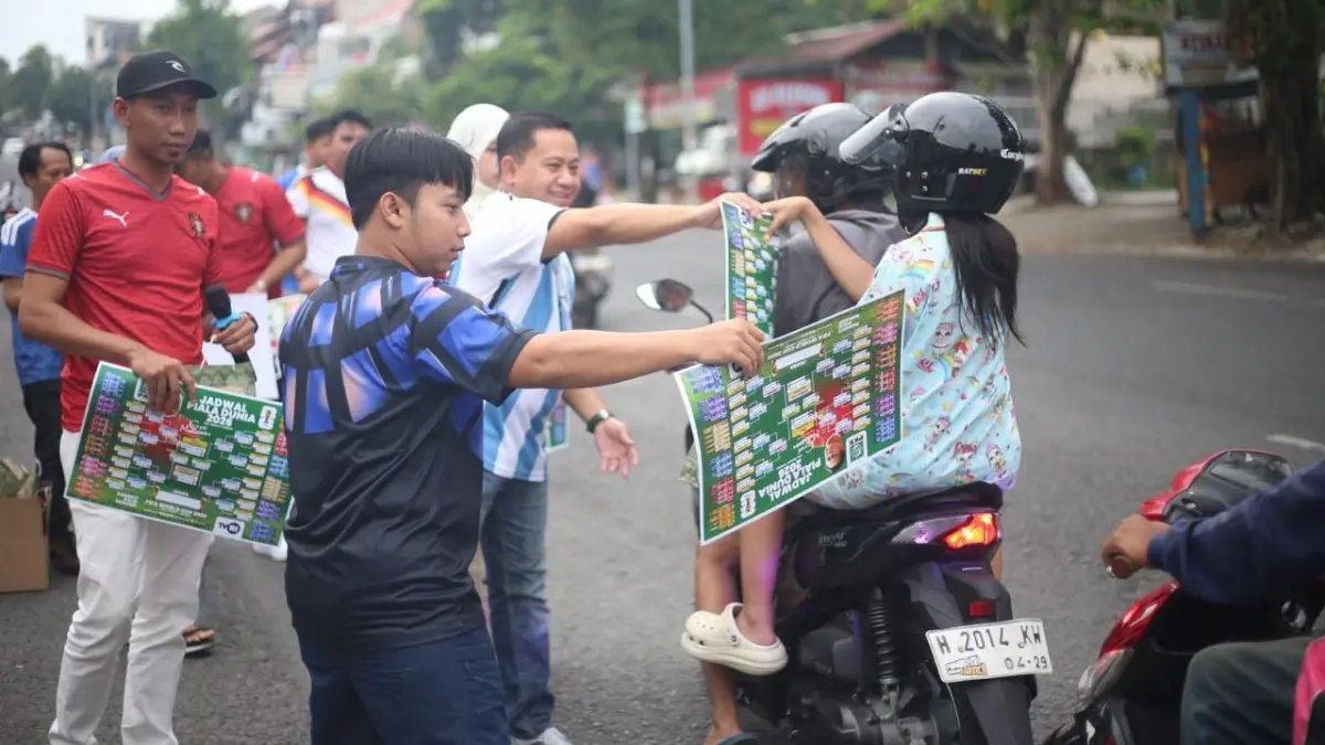 Para kader Garda Bangsa membagikan poster jadwal Piala Dunia bergambar Cak Imin plus logo TVRI di halaman kantor DPW PKB Jawa Tengah di Semarang, Jumat (12/6/2026). (Istimewa)