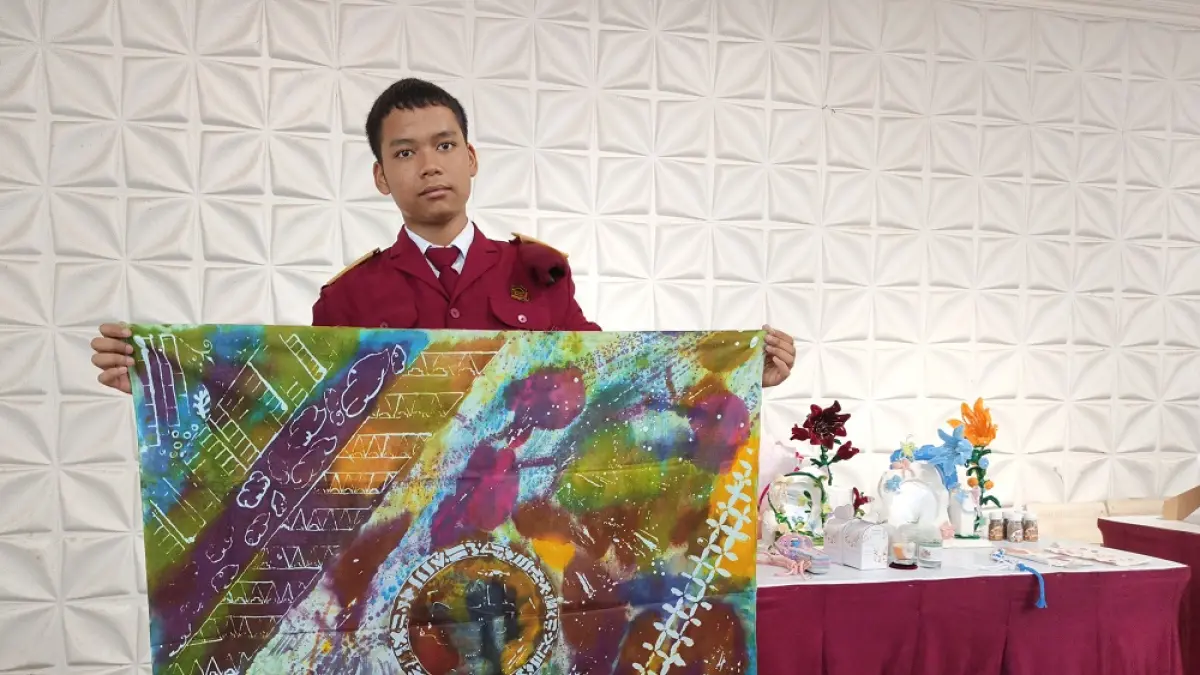 Siswa SRMA 43 Magelang Usman Ardiansyah menunjukkan kain batik hasil karya siswa saat kegiatan open house. (ROFIK SYARIF/ JAWA POS RADAR MAGELANG)
