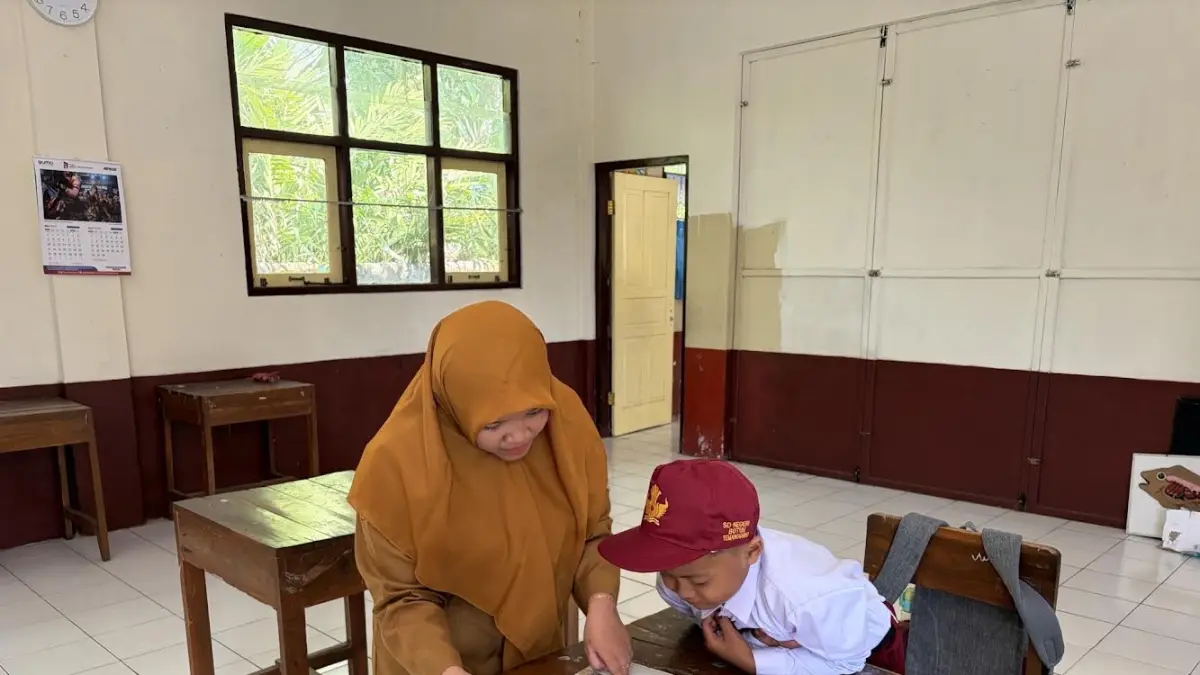 Guru SDN Butuh Temanggung menjelaskan pelajaran pada satu siswanya. Pemkab Temanggung akan melibatkan guru ngaji untuk menarik minat masuk SD negeri. (Dok Jawa Pos Radar Magelang)