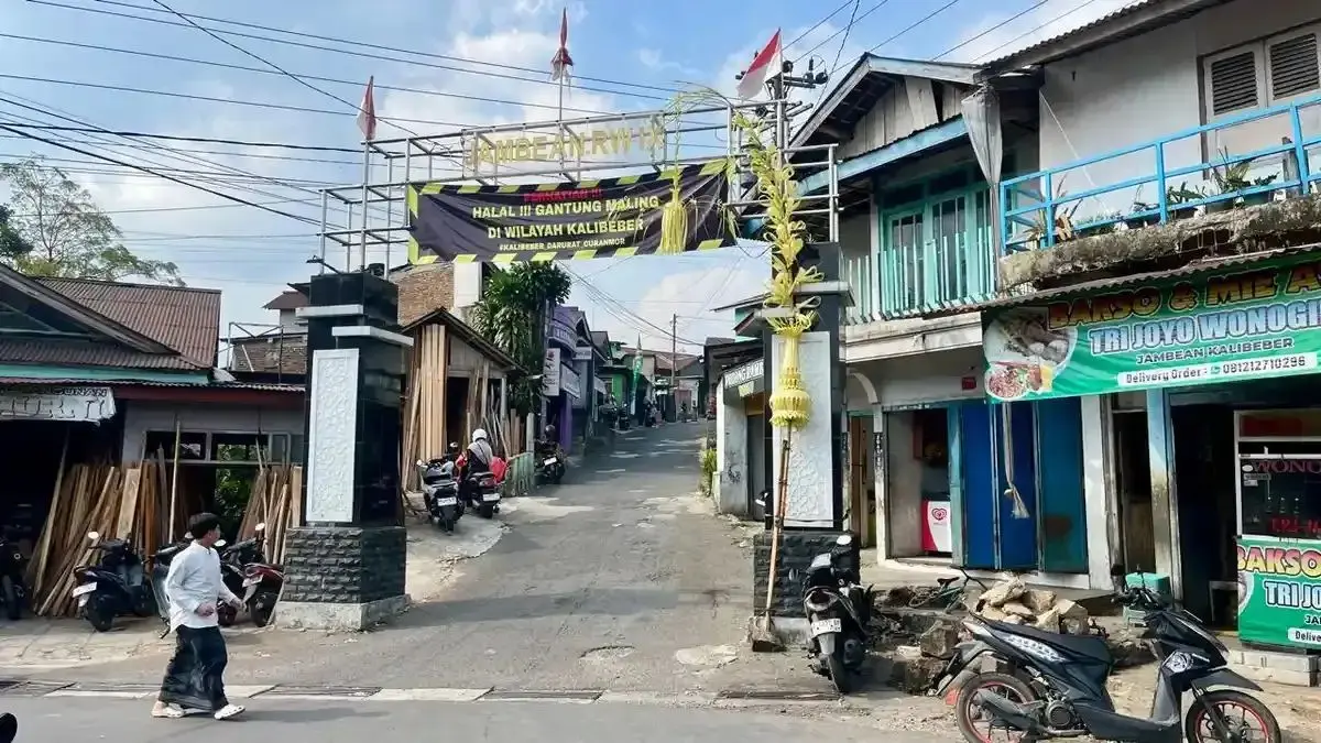 Pejalan kaki melihat spanduk bertuliskan ancaman pada pencuri motor yang dipasang di jalan masuk kampung di Kalibeber, Mojotengah, Wonosobo.&nbsp;(Istimewa)