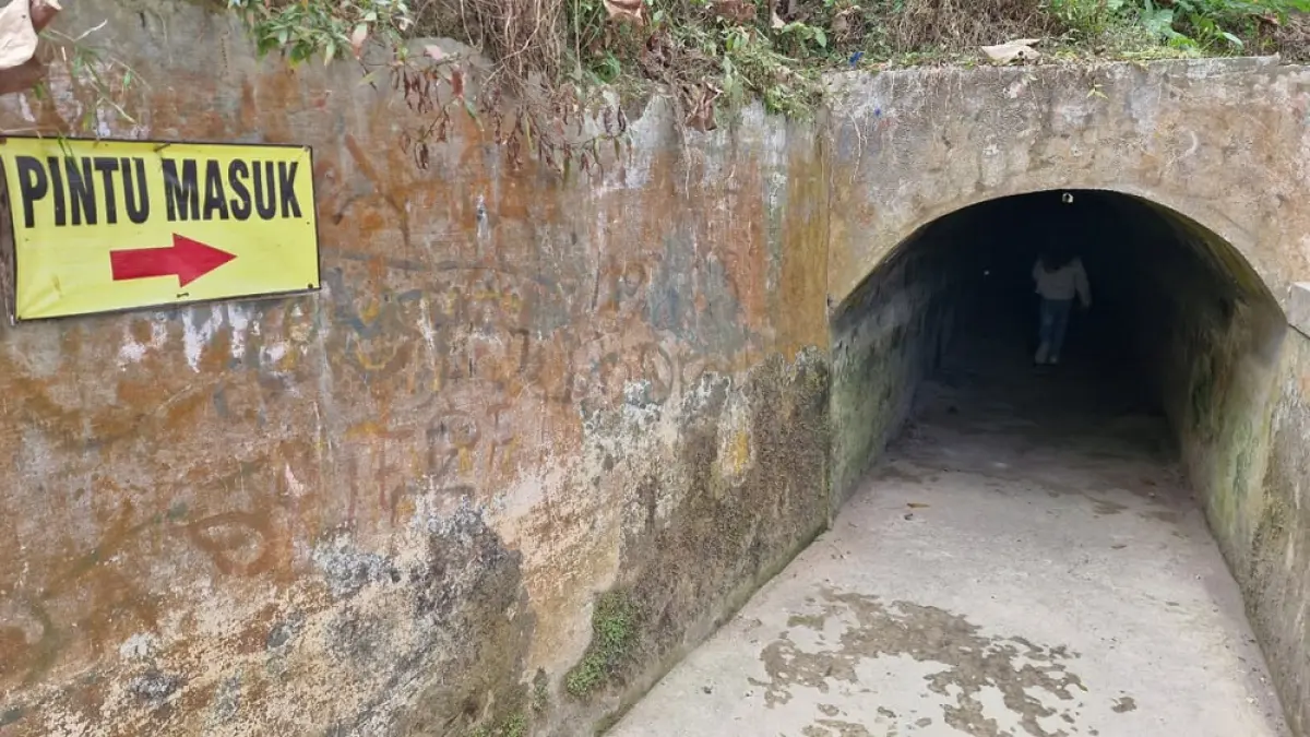Seorang pengunjung memasuki terowongan saluran irigasi kuno di kawasan wisata air terjun Kedung Kayang. (PUPUT PUSPITASARI/JAWA POS RADAR MAGELANG)