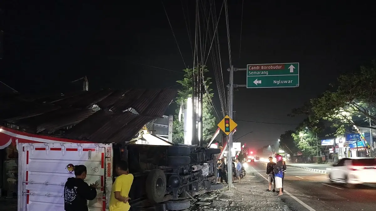Truk pengangkut paket terguling dan menabrak pagar rumah hingga tempat cucian motor dan hampir menabrak ATM BRI Kantor Unit Salam, Selasa (4/8/2026) malam. (ROFIK SYARIF/ JAWAPOS RADAR MAGELANG)