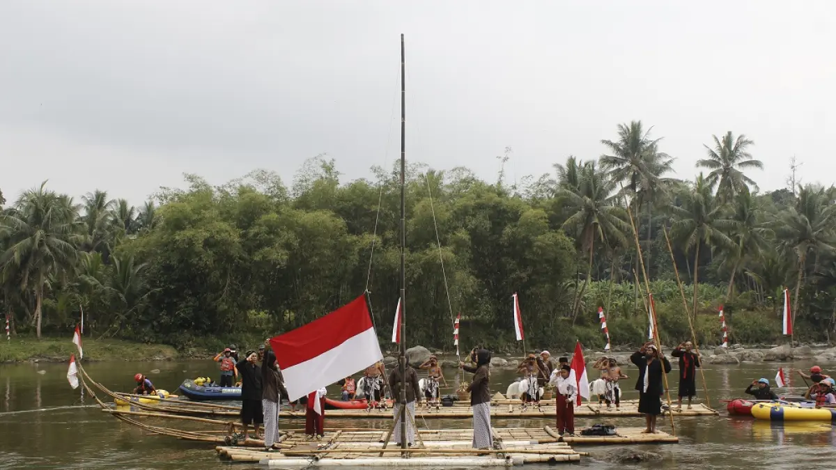 Pengibaran bendera Merah Putih di atas getek yang berlokasi di tengah Sungai Progo, Dusun Gleyoran, Desa Sambeng, Kecamatan Borobudur, Kabupaten Magelang, Senin (17/8/2026). (JIHAN ZALFATUL NUR’AINI/JAWA POS RADAR MAGELANG)