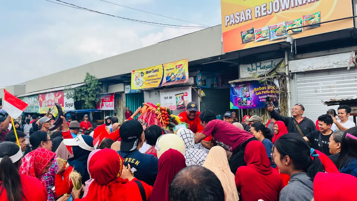 Pengunjung dan pedagang Pasar Rejowinangun antusias menggerebek tiga gunungan komoditas pasar, Senin (17/8/2026). (PUTRI NASYWA KHAIRUNISA / JAWA POS RADAR MAGELANG)