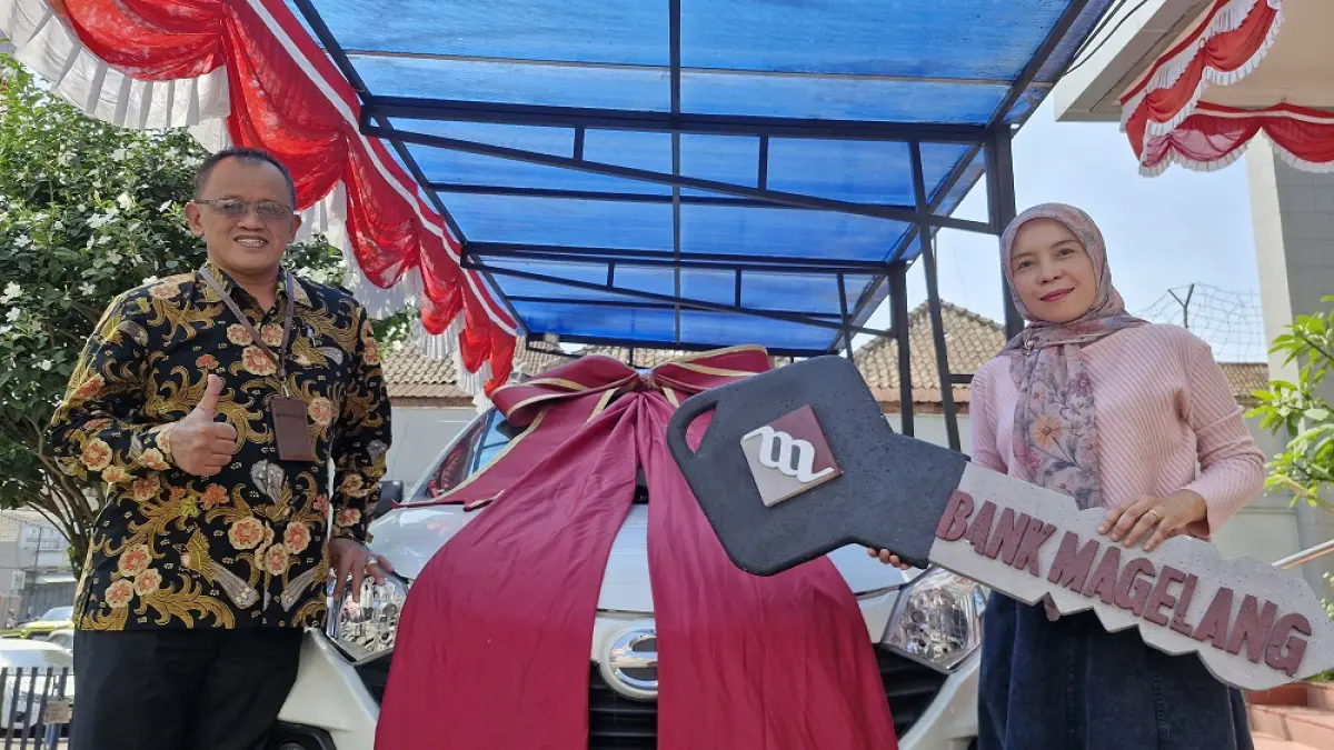Direktur PT BPR Bank Magelang (Perseroda) Bank Magelang Taufik Hidayat menyerahkan hadiah utama kepada Desi Eviana, pemenang undian tabungan periode Juli 2026, Jumat (21/8/2026). (PUPUT PUSPITASARI/JAWA POS RADAR MAGELANG)