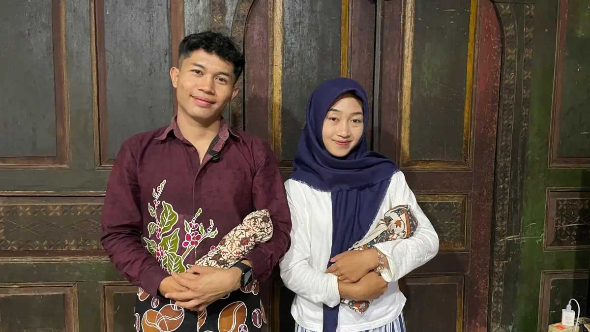Dua remaja membawa boneka dari gulungan jarik yang dikenal dengan golek tholo di Desa Slukatan. (Istimewa)