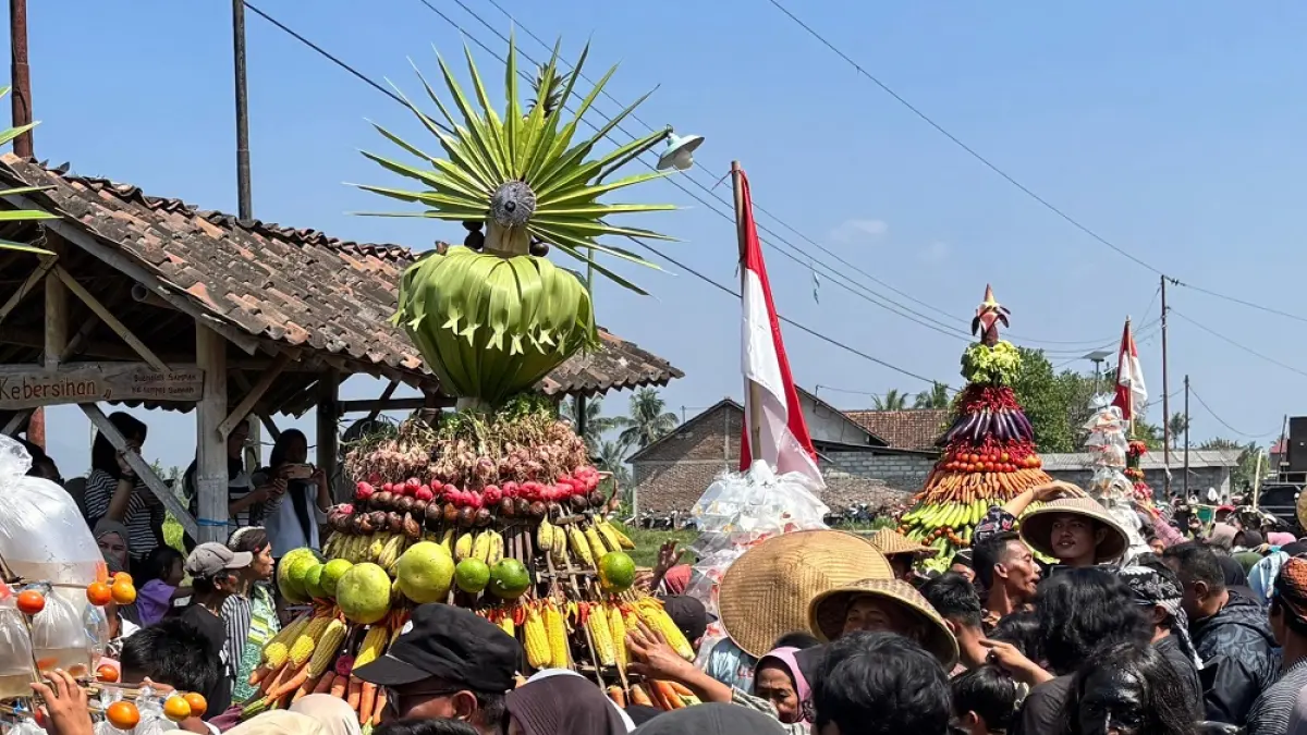 Warga berebut gunungan hasil bumi dan gunungan ikan saat festival budaya yang digelar di Desa Ngrajek, Kecamatan Mungkid, Kabupaten Magelang, Minggu (30/8/2026). (ROFIK SYARIF/ JAWA POS RADAR MAGELANG)