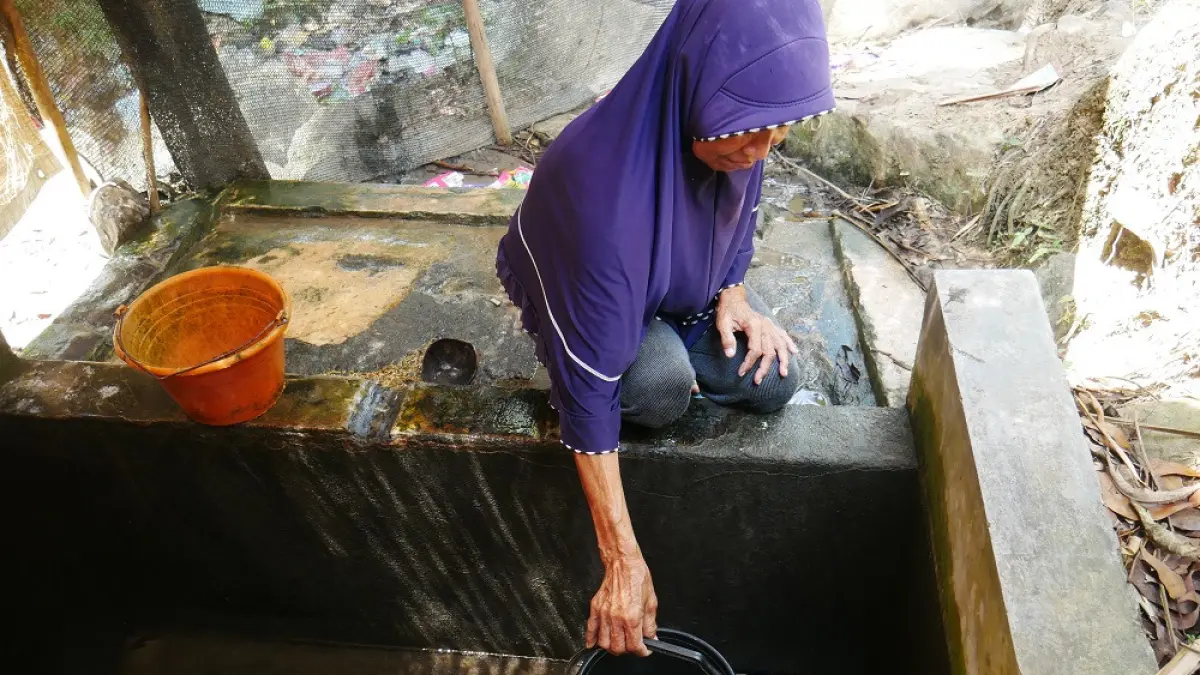 Warga ngangsu di salah satu sumber air di Dusun Kebon Mentok, Desa Paripurno, Kecamatan Salaman, Kabupaten Magelang yang debitnya berkurang.(DWIAYU MULAN SYAWALIA/JAWA POS RADAR MAGELANG)