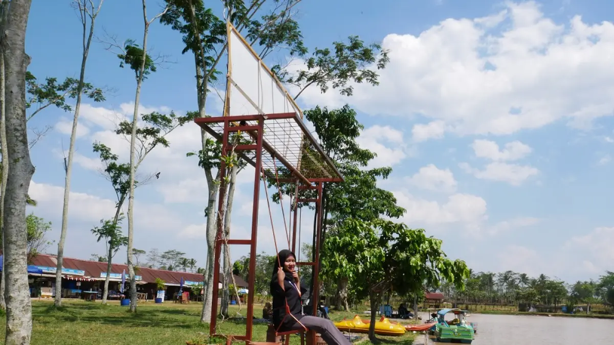 Pengunjung menikmati salah satu fasilitas ayunan di objek wisata Rawa Gembongan. (SUCI AYU STIANINGRUM/JAWA POS RADAR MAGELANG)
