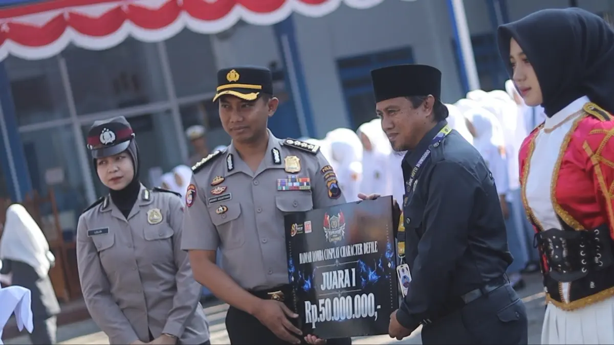 Kombes Pol Andry Agustiano menyerahkan mock up uang pembinaan Rp 50 juta kepada Kepala SMK Mutu Wonosobo Setya Rahmawanto, Senin (21/9/2026). (Istimewa)