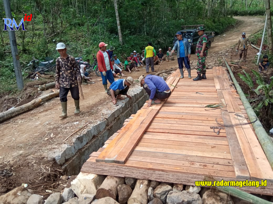 Anggota Koramil 02/Watumalang bersama warga Desa Mutisari, Watumalang memperbaiki jembatan desa setempat yang rusak, pekan lalu. (IST)