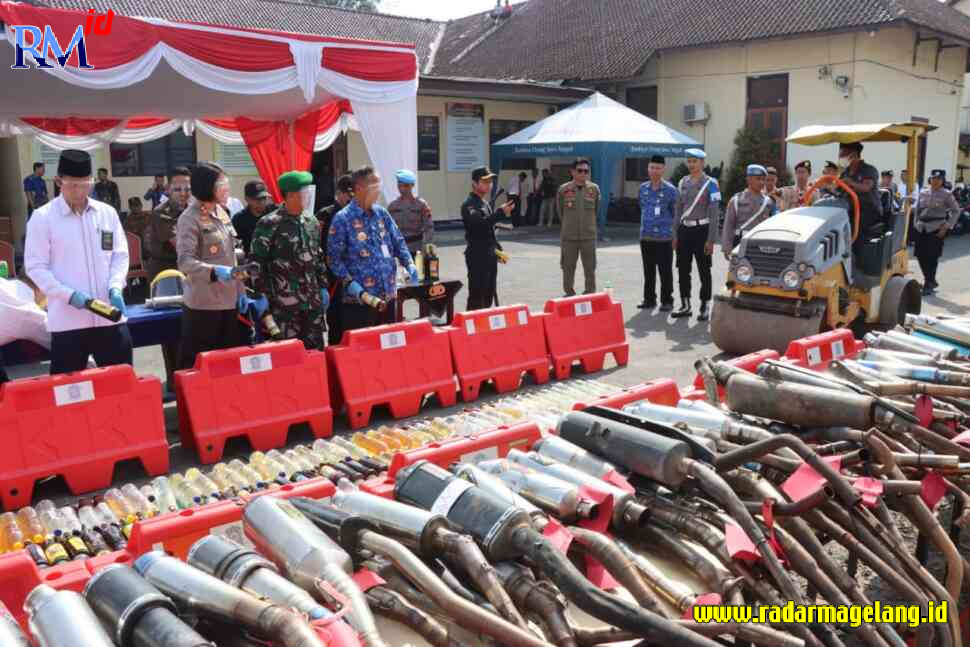 Alat berat melindas ribuan botol miras di halaman belakang Polres Magelang Kota, Senin (17/4). (ROFIK SYARIF G P/RADAR MAGELANG)