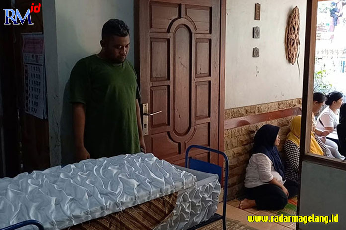 Putra pertama almarhum Benjo, Ridwan Iga Saleh berada di dekat peti almarhum Benjo di rumah duka Kampung Kedung Tungkul RT 03 RW 06 Kelurahan Mojosongo, Kecamatan Jebres, Jumat (26/5). (SILVESTER K/RADAR SOLO)