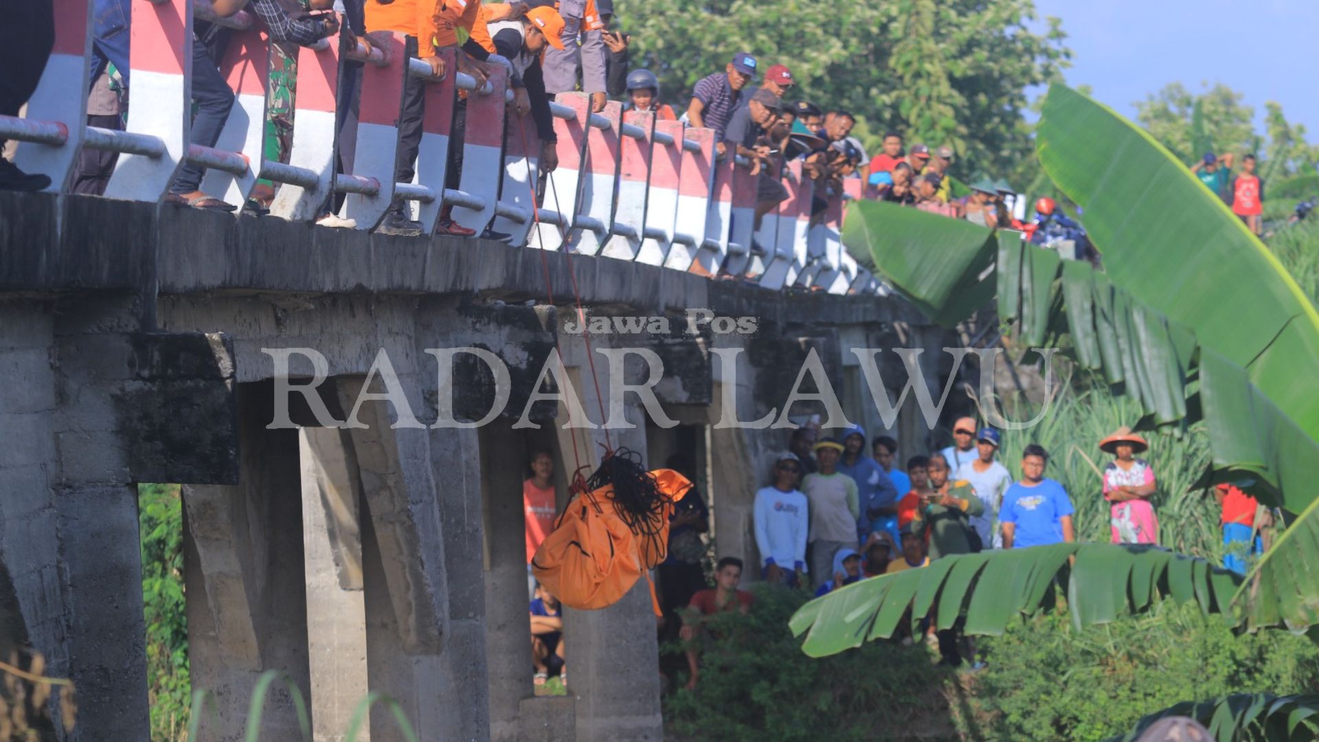 DIEVAKUASI: Tim Gabungan mengevakuasi jasad Suwardji yang ditemukan di bawah jembatan Dusun Pojok, Desa Sogo, Balerejo, Kabupaten Madiun, Jumat (12/1). (R. BAGUS RAHADI/RADAR MADIUN)