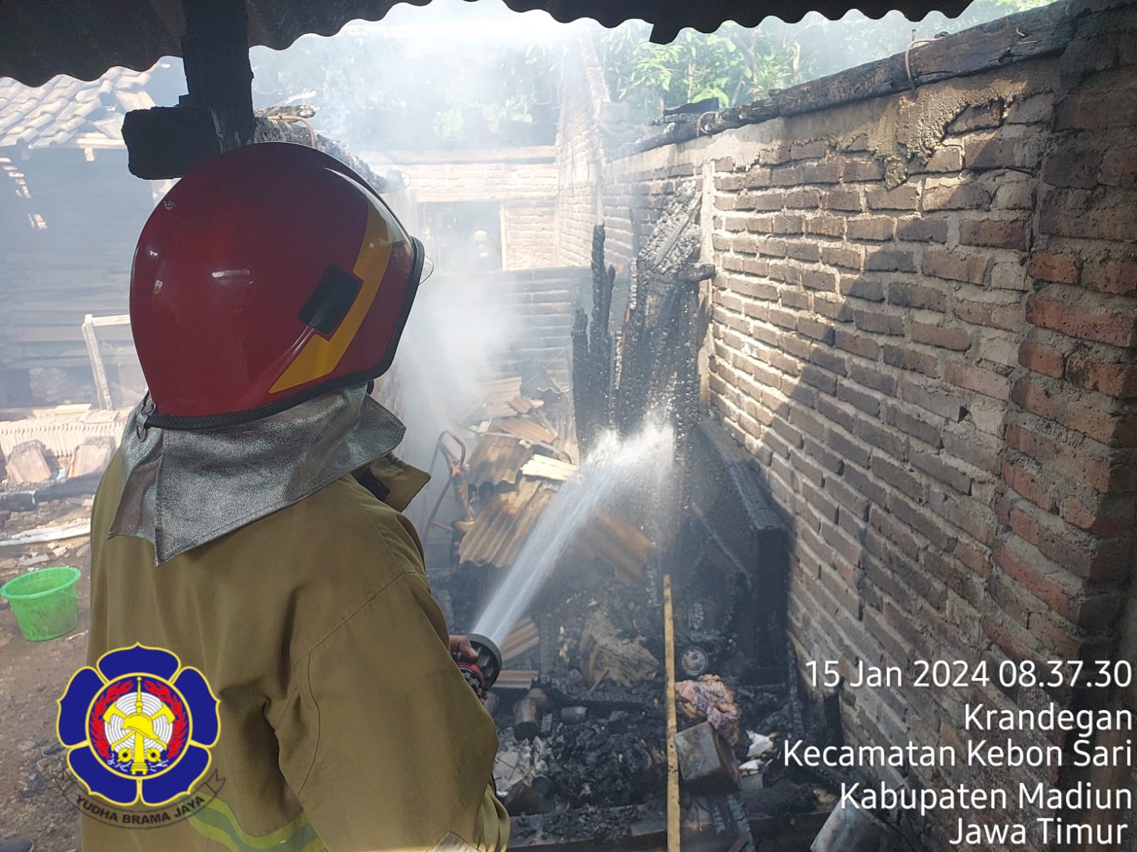 HANGUS: Petugas damkar melakukan pembasahan di gudang barang miliki warga Desa Krandegan, Dolopo yang terbakar, Senin (15/1). (DAMKAR KAB. MADIUN FOR JAWA POS RADAR LAWU)