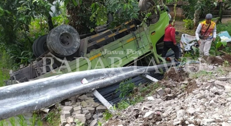 TERBALIK: Kendaraan truk bermuatan besi terbalik di Tikungan Sebalok, Desa Pendem, Kecamatan Ngariboyo Magetan, Selasa (31/1). (AJI PUTRA/JAWA POS RADAR MAGETAN).