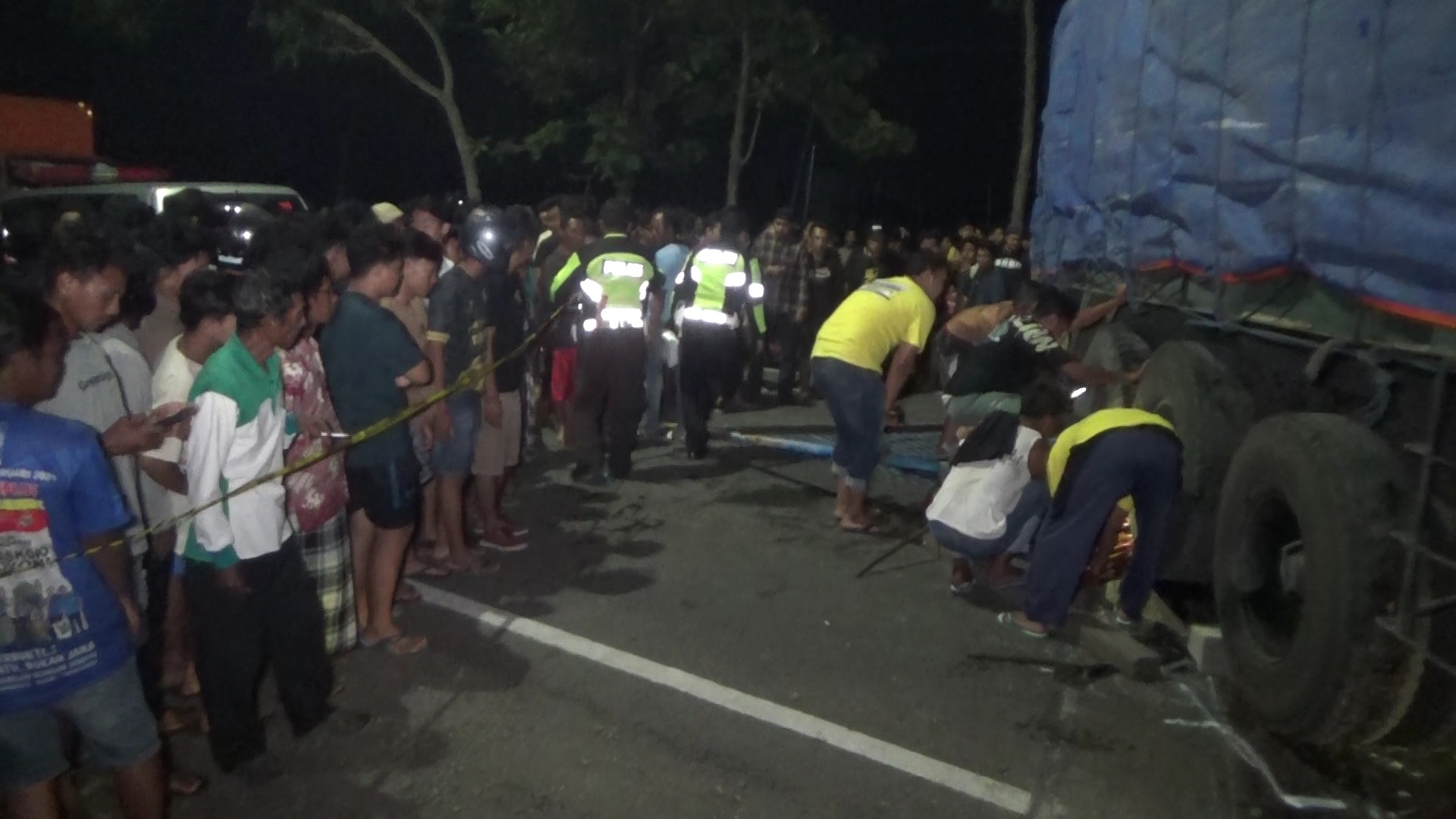 DRAMATIS: Usaha warga mengevakuasi David Dwi Yulianto yang kunduran truk di Karangjati, Ngawi, pada Senin (19/2) malam. (ASEP SYAEFUL BACHRI/JAWA POS RADAR NGAWI)