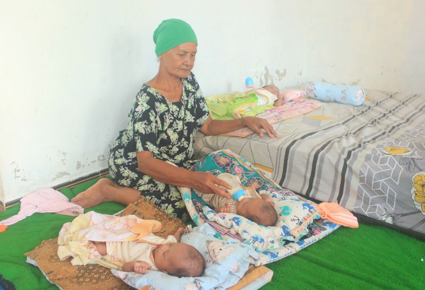SEHAT SELALU: Boinem bersama cucunya yang kembar tiga. (LODITYA FERNANDES/JAWA POS RADAR MADIUN)