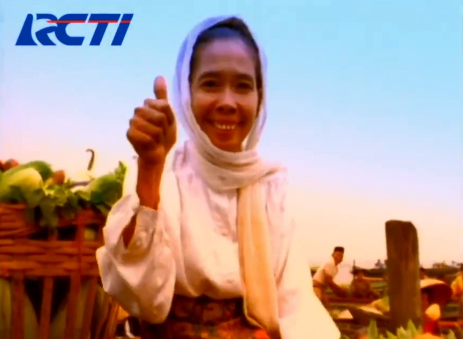 Pemeran dalam iklan RCTI di pasar terapung mengacungkan jempolnya.