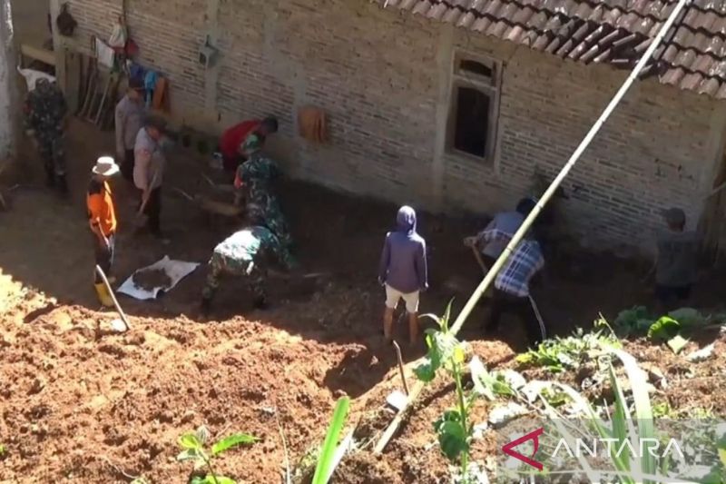 KERJA BAKTI: Warga membersihkan material longsor yang merusak dua rumah di Poncol, Ngawi, Senin (26/2). (ANTARA)
