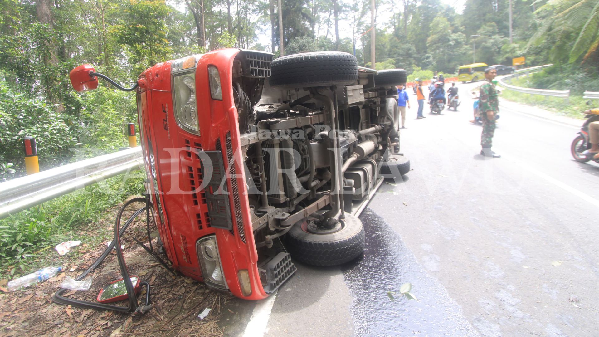 MUSIBAH: Minibus Isuzu Elef nopol S 7283 A terguling di tanjakan atasnya Lawu Green Forest Magetan pukul 11.30 hari ini (3/3). (AJI PUTRA/JAWA POS RADAR MAGETAN)