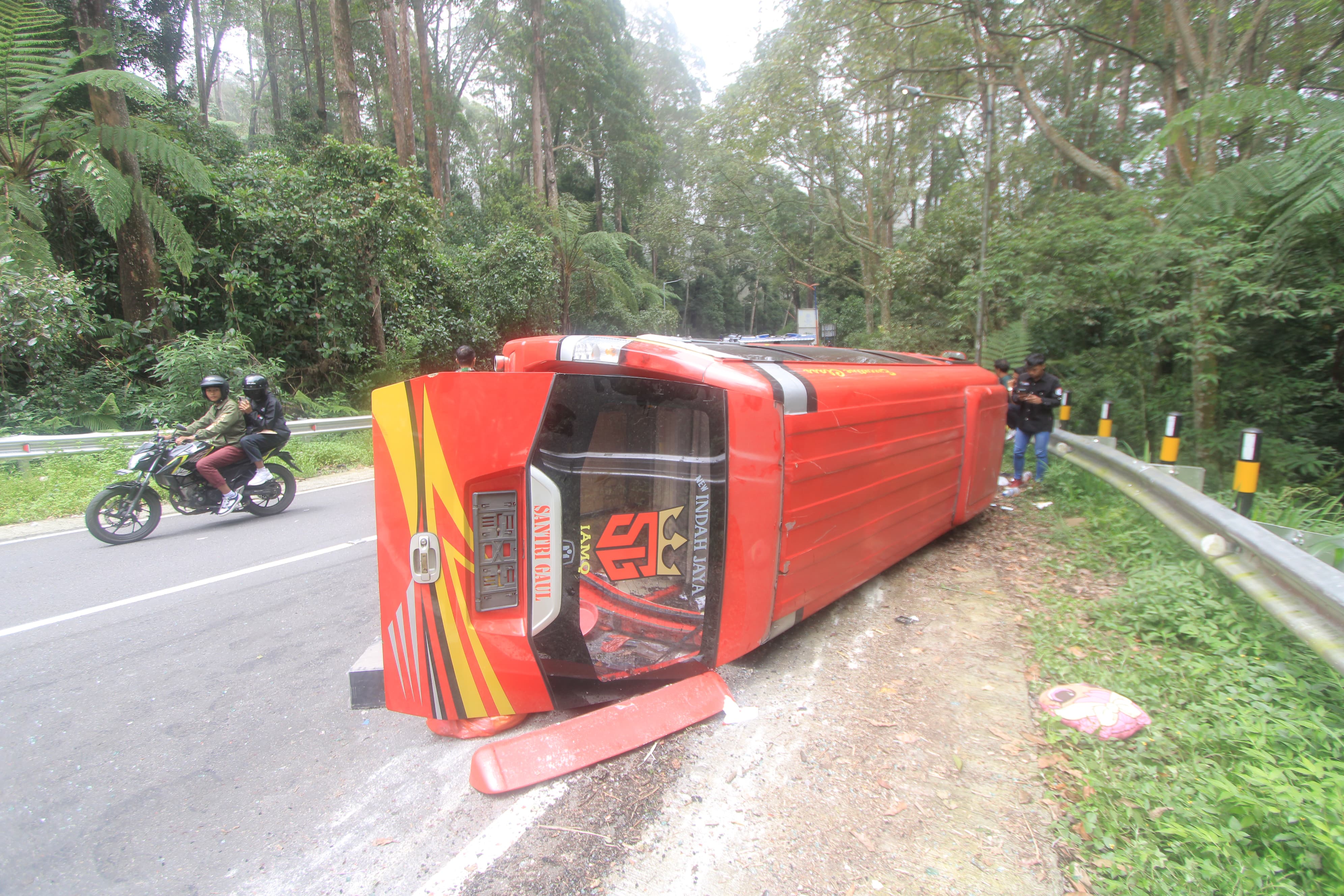 CELAKA: Isuzu Elf berpenumpang 15 orang mengalami kecelakaan tunggal di tikungan barat LGF, Magetan, Minggu (3/3) siang. (AJI PUTRA/RADAR MAGETAN)