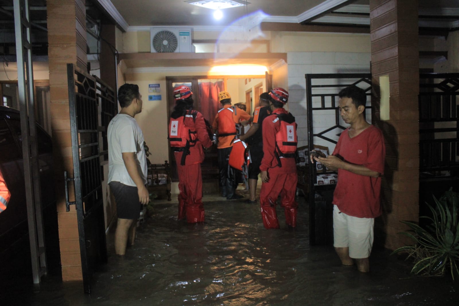 BENCANA: Petugas mengevakuasi warga terdampak banjir di perumahan Ardya Garini, Suratmajan, Maospati, Magetan, pada Selasa (5/3). (AJI PUTRA/JAWA POS RADAR MADIUN)