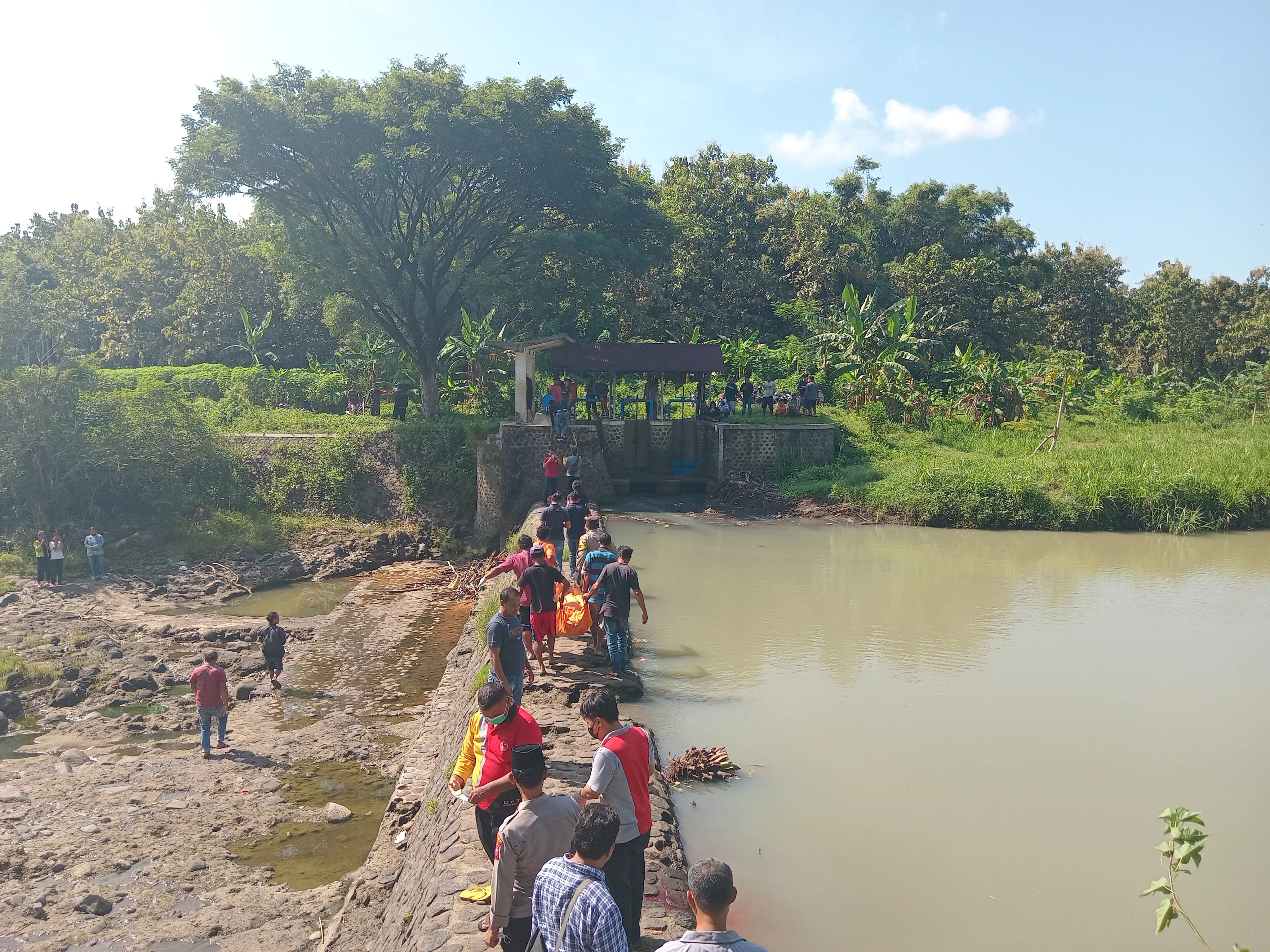 BIKIN GEGER: Suasana evakuasi jasad Febrianto di dam sungai Desa Widodaren, Gerih, Ngawi, Jumat (29/3). (ASEP SYAEFUL BACHRI/JAWA POS RADAR NGAWI)