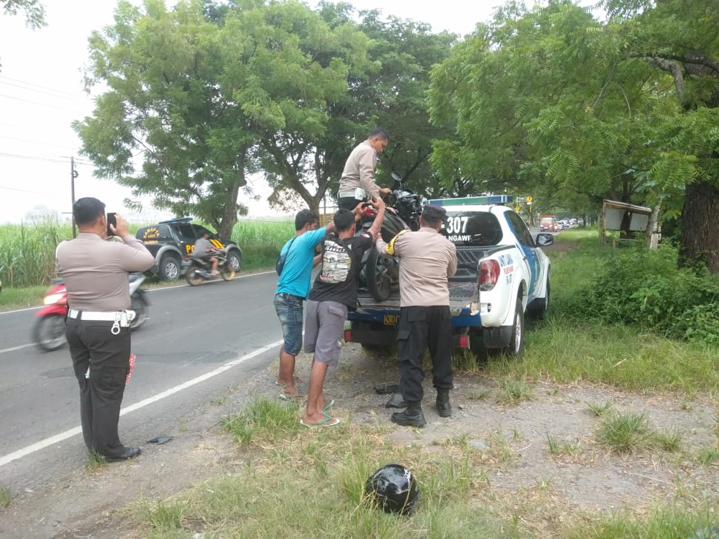 TABRAKAN: Petugas mengangkut motor Vario yang terlibat laka lantas dengan truk dam di Jalan Raya Ngawi-Maospati, Selasa (2/4).&nbsp; (SATLANTAS UNTUK JAWA POS RADAR NGAWI)
