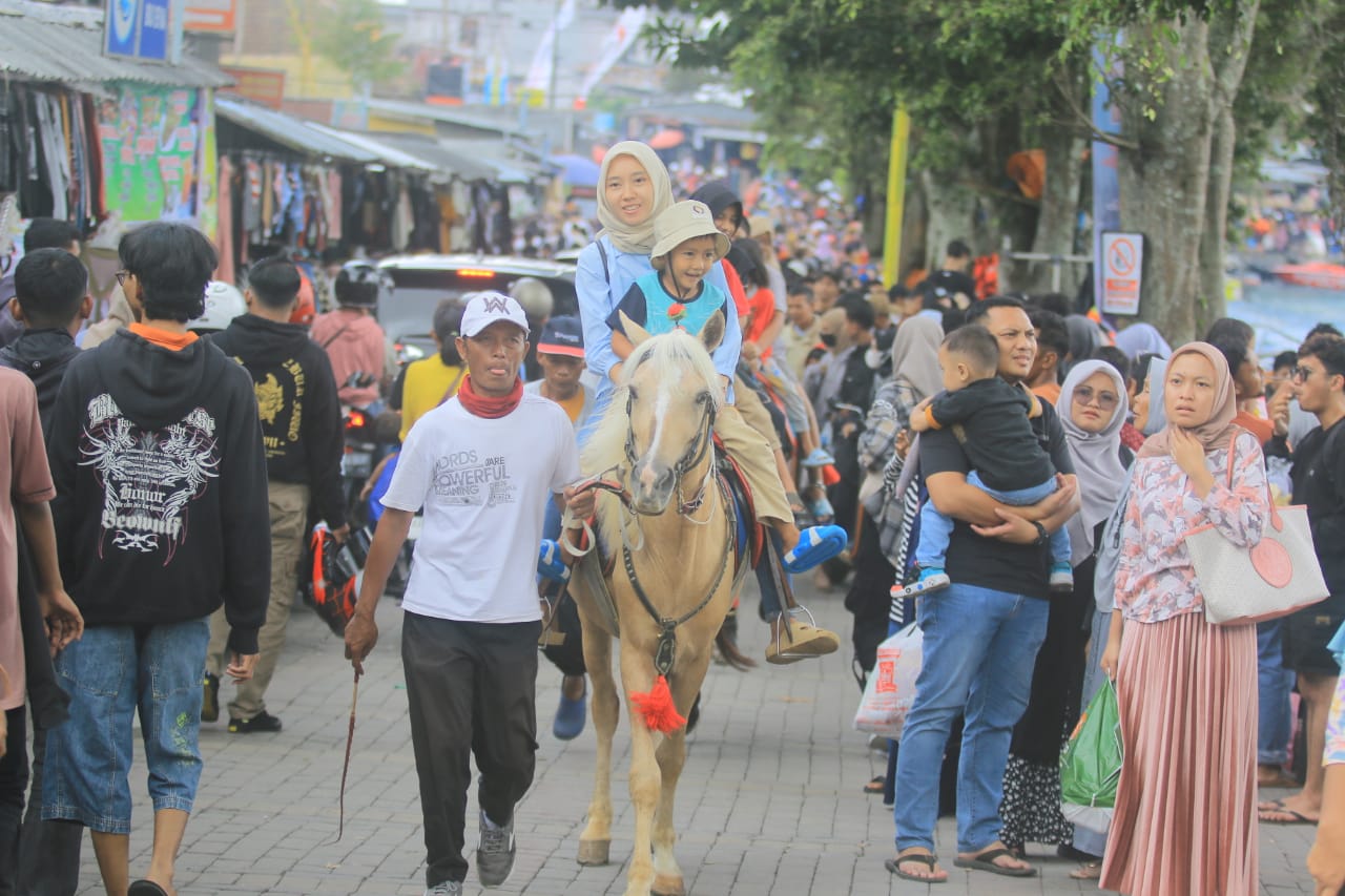 RAMAI: Puluhan ribu pengunjung padati kawasan Telaga Sarangan, Sabtu (13/4). (BAGAS BIMANTARA/JAWA POS RADAR MAGETAN)
