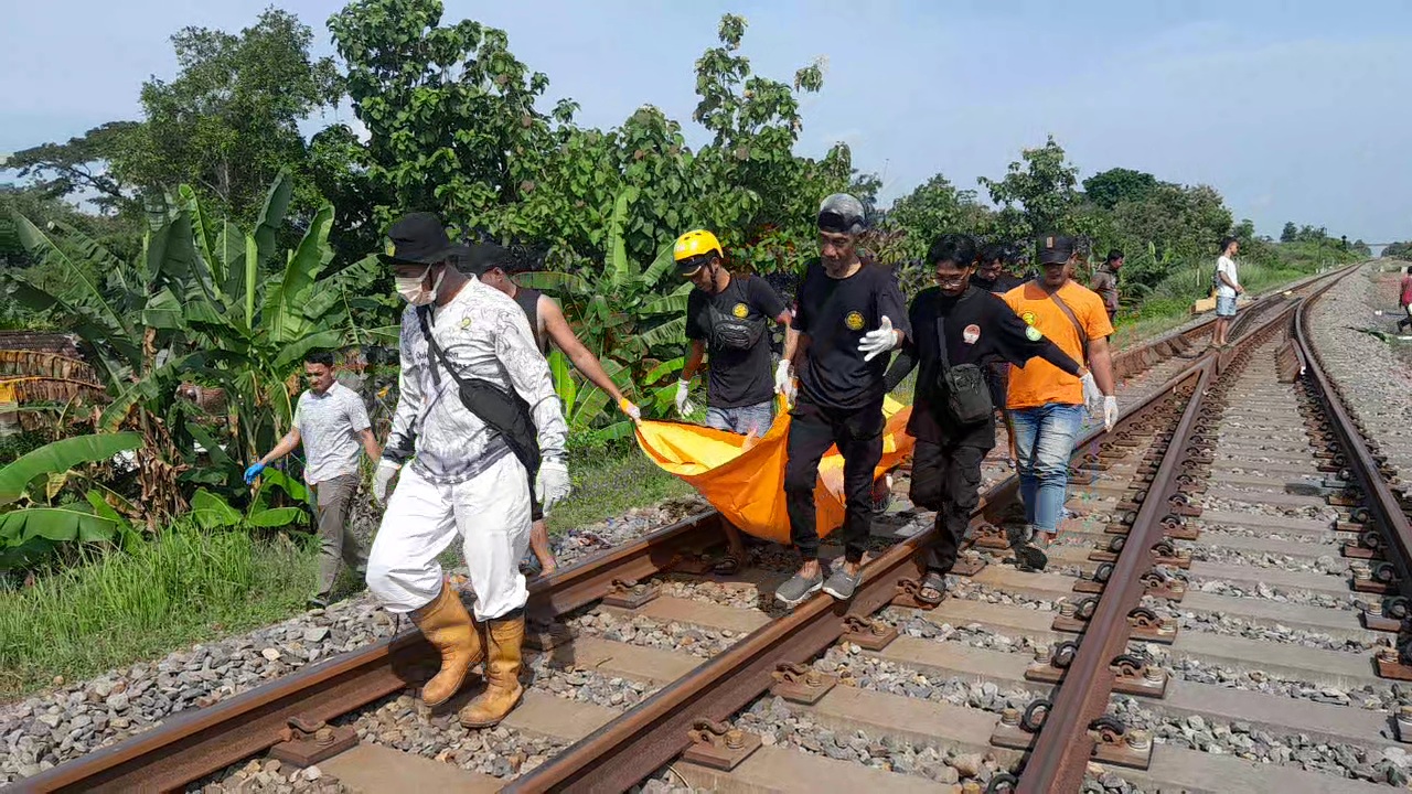 EVAKUASI: Petugas membawa potongan jasad yang ditemukan di jalur rel kereta api di Desa Gendingan, Widodaren, Ngawi, Rabu (24/4). (ASEP SYAEFUL BACHRI/JAWA POS RADAR NGAWI)